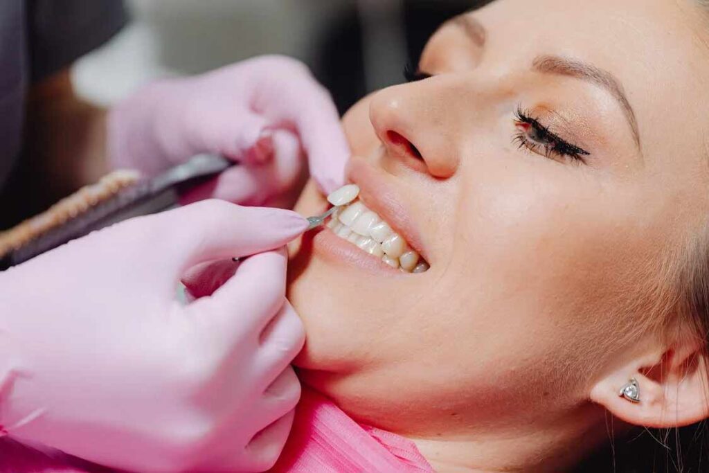 A porcelain dental veneer is placed on a patient to improve their smile.